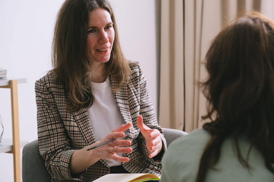 Pensive woman psychologist with brown hair in stylish clothes sitting and talking